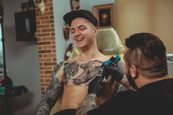 Homem tendo seu peito tatuado Homem tendo seu peito tatuado