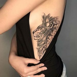 Tatuagem feminina de leão nas costelas