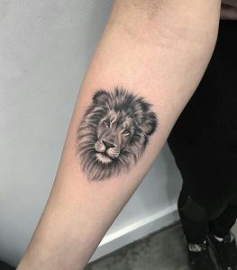 Tatuagem feminina de leão no braço