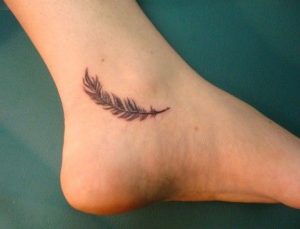 tatuagem feminina no pé de penas