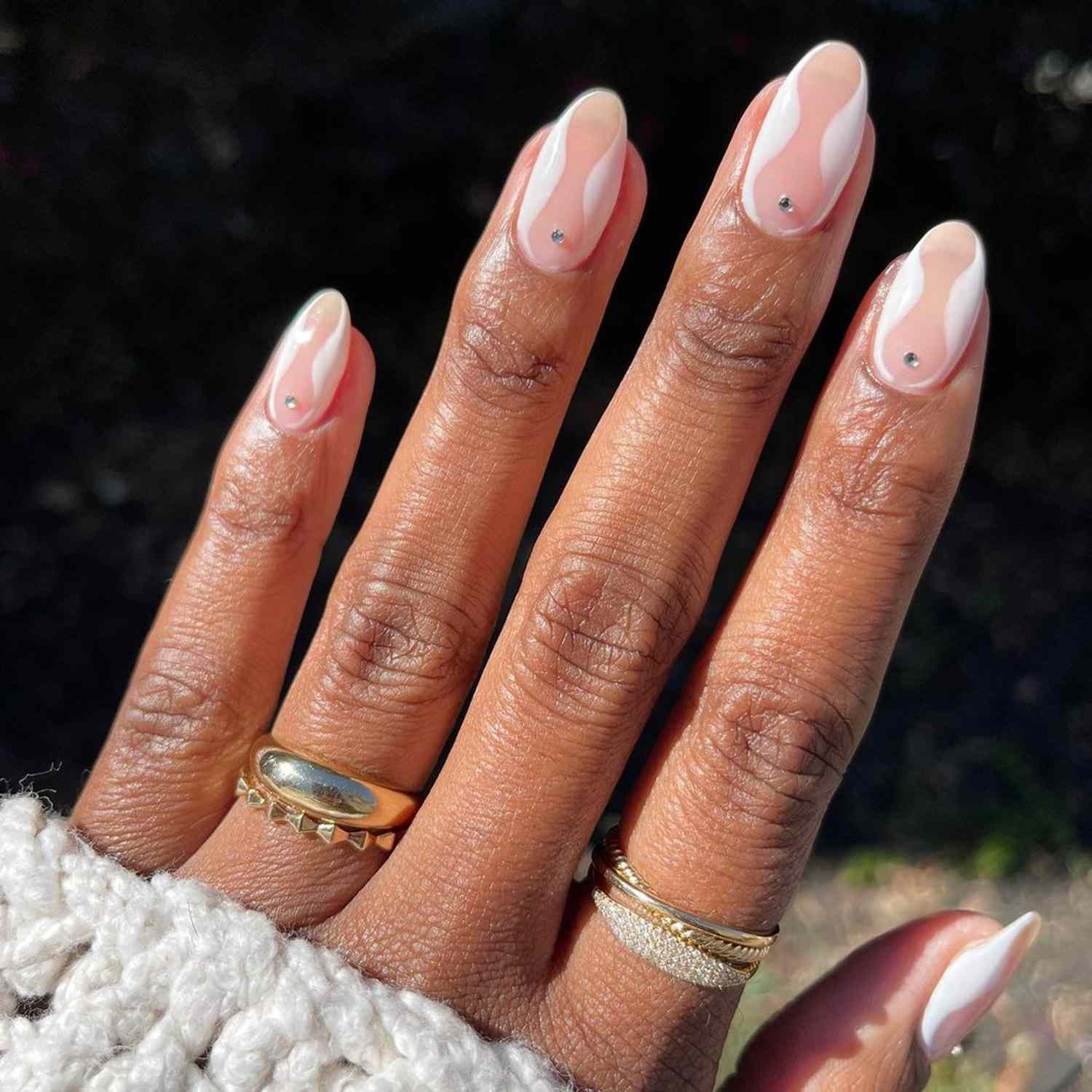 unhas com desenho minimalista abstrato e pontos de strass