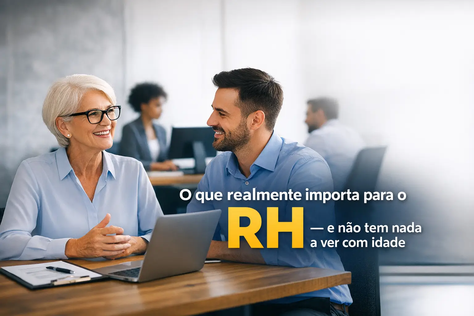 Mulher idosa e homem jovem conversando em mesa com laptop sobre RH
